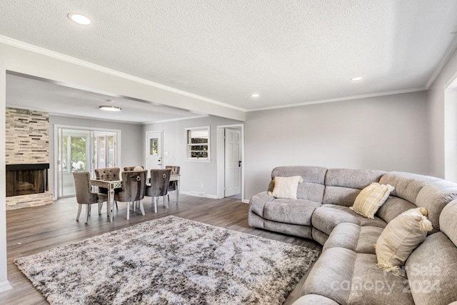 living room with a textured ceiling, ornamental molding, and wood-type flooring