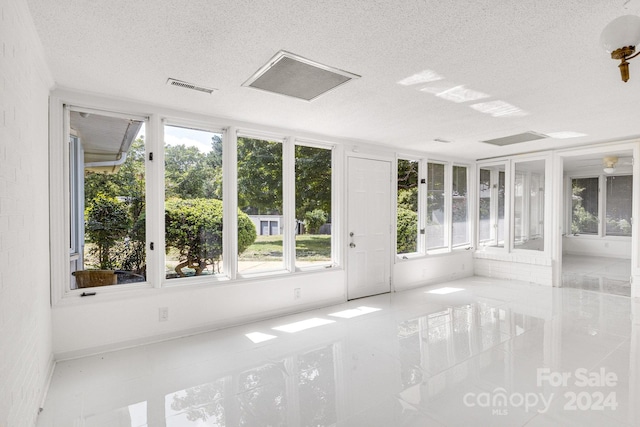 tiled empty room with a textured ceiling