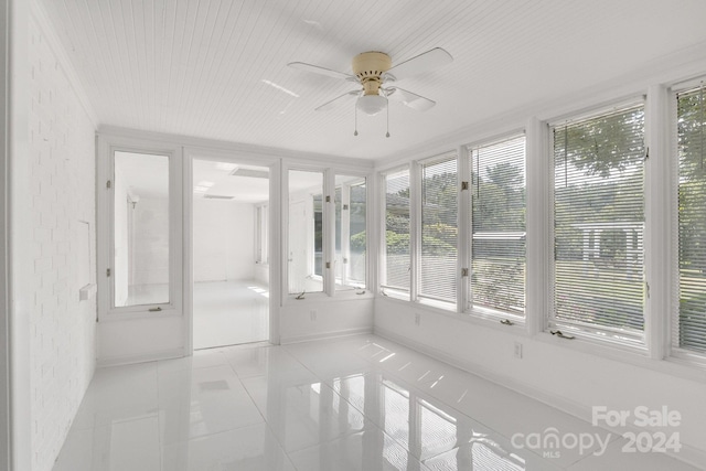 unfurnished sunroom featuring ceiling fan