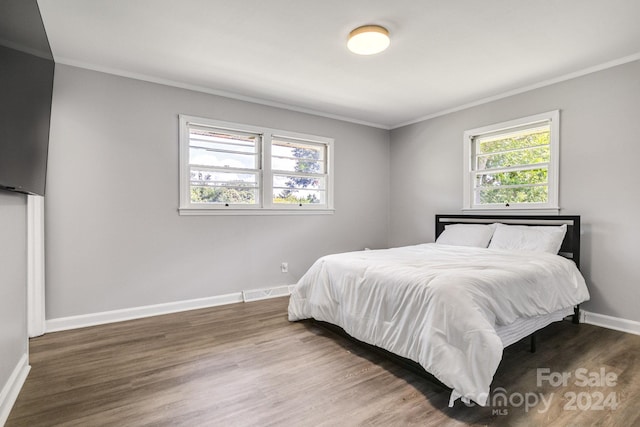 bedroom with crown molding and wood-type flooring