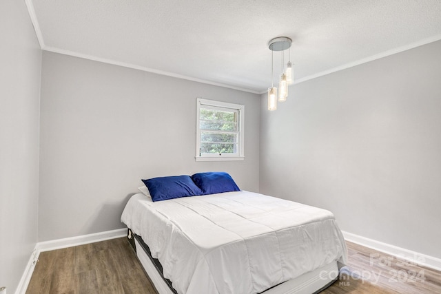 bedroom with hardwood / wood-style floors and ornamental molding