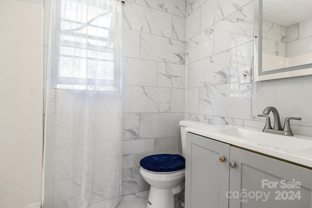 bathroom with tile walls, toilet, vanity, and walk in shower