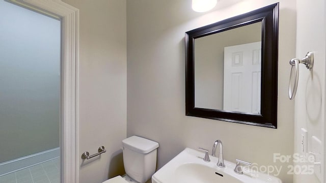 half bathroom featuring a sink and toilet