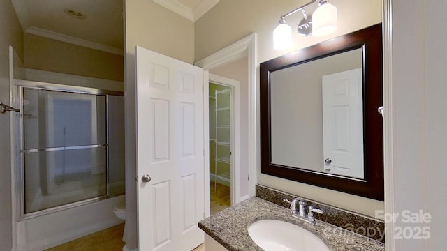 full bathroom featuring toilet, bath / shower combo with glass door, ornamental molding, and vanity