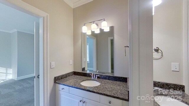 bathroom featuring ornamental molding, two vanities, and a sink