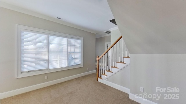 stairway with carpet floors, baseboards, visible vents, and crown molding