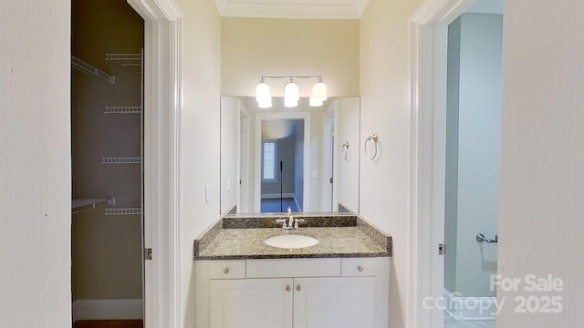 bathroom with a walk in closet and vanity