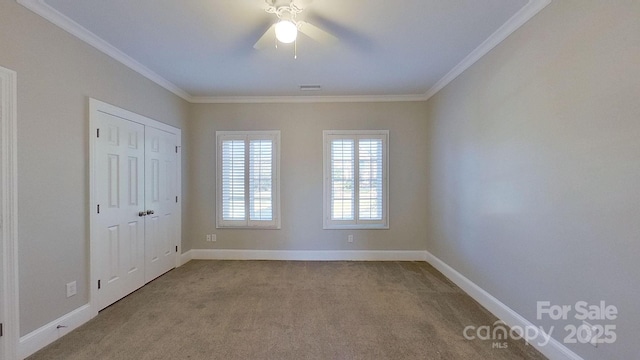 unfurnished room featuring baseboards, crown molding, and light colored carpet