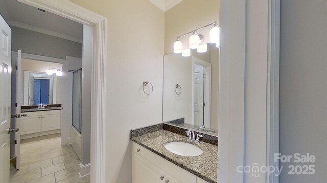 bathroom featuring shower / bath combination with glass door, crown molding, and vanity