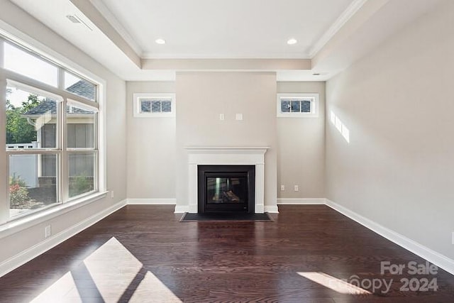 unfurnished living room with dark wood-type flooring, a tray ceiling, and ornamental molding