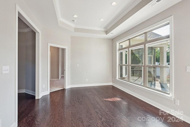 spare room with a tray ceiling, dark hardwood / wood-style floors, and crown molding