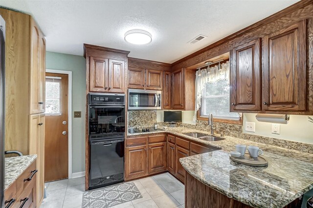 kitchen with light tile patterned floors, stone counters, sink, and double oven