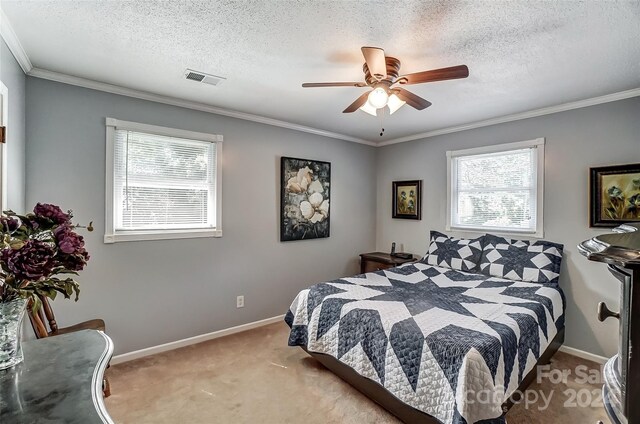 bedroom with light carpet, a textured ceiling, ornamental molding, and ceiling fan