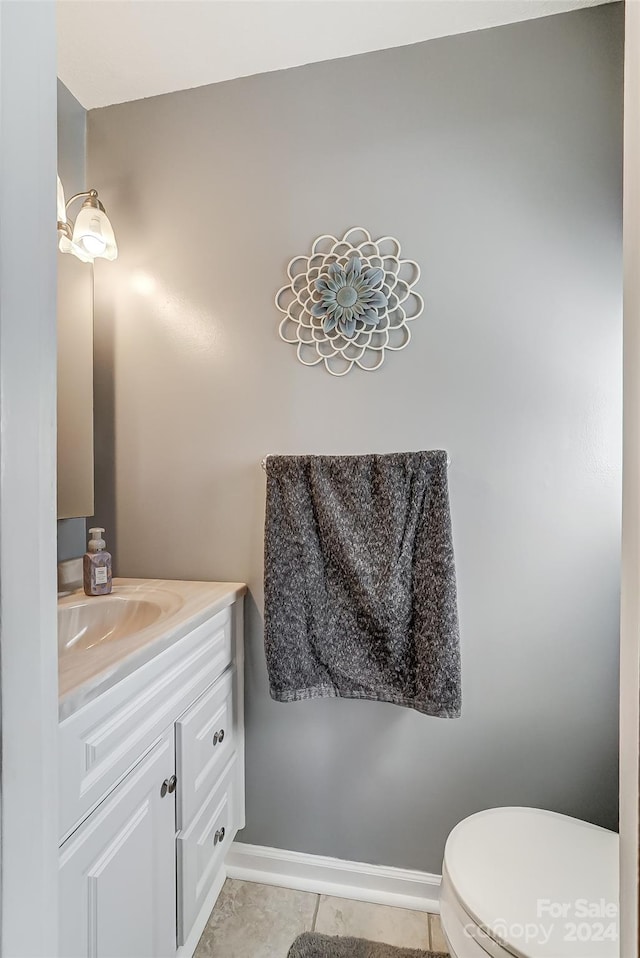 bathroom with vanity, tile patterned flooring, and toilet