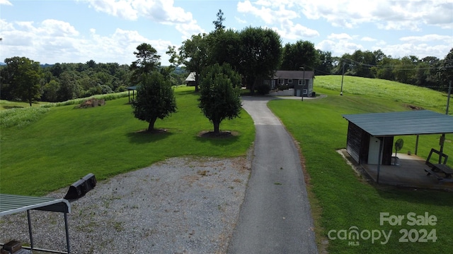 view of property's community with an outbuilding and a yard