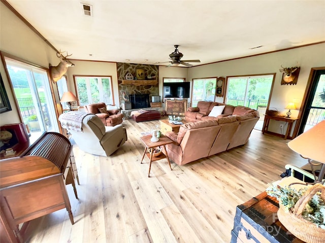 living room featuring a fireplace, light hardwood / wood-style floors, ceiling fan, and ornamental molding