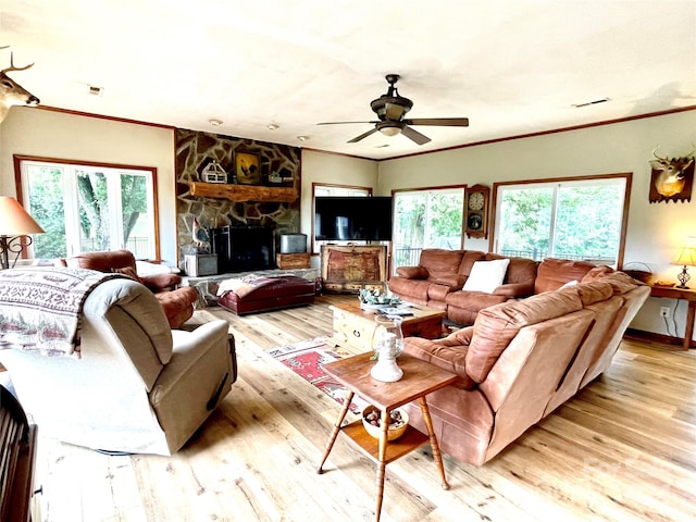 living room featuring ceiling fan, light hardwood / wood-style floors, ornamental molding, and a wealth of natural light