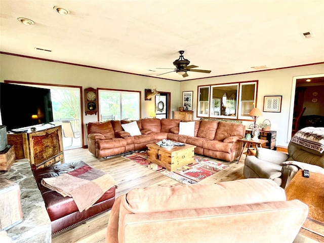 living room featuring light hardwood / wood-style floors, ceiling fan, and crown molding