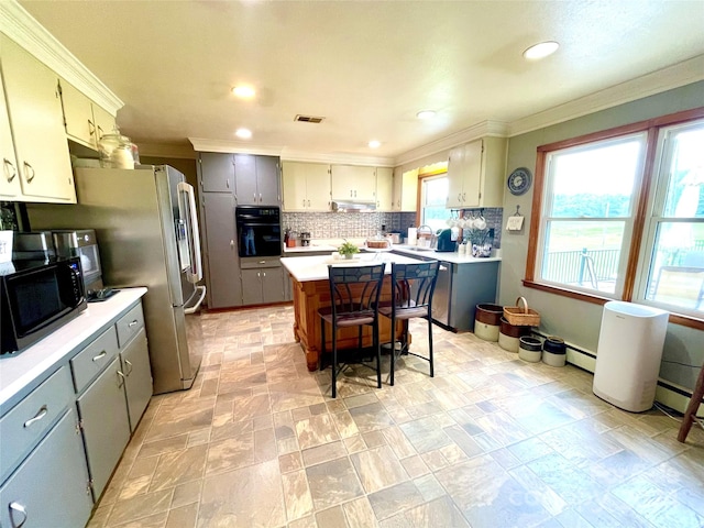 kitchen with decorative backsplash, crown molding, black appliances, a center island, and gray cabinets