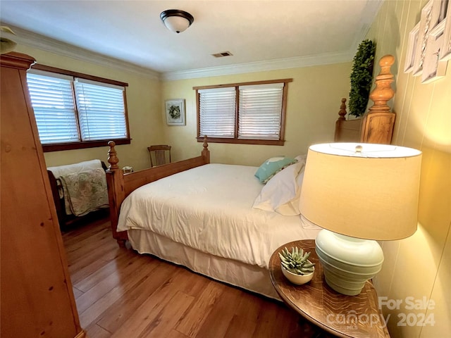 bedroom featuring ornamental molding and hardwood / wood-style flooring