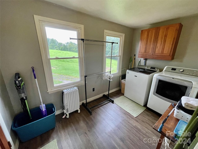 washroom featuring washer and dryer, hardwood / wood-style floors, plenty of natural light, and cabinets