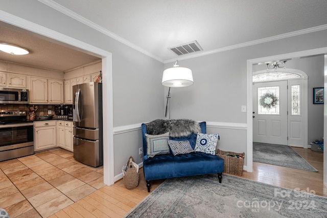 kitchen featuring stainless steel appliances, ornamental molding, and light hardwood / wood-style floors