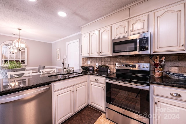 kitchen featuring pendant lighting, sink, stainless steel appliances, ornamental molding, and dark stone counters