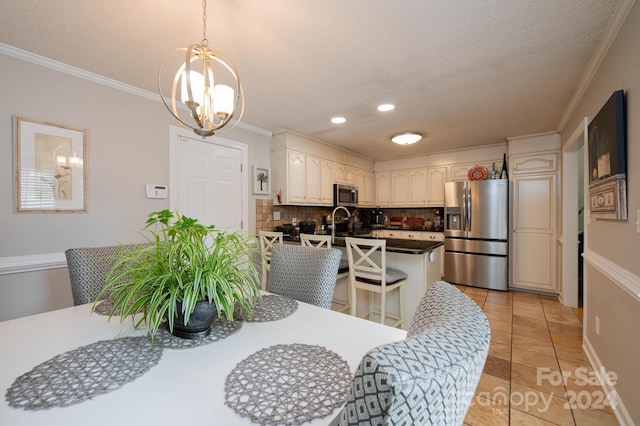 tiled dining space with an inviting chandelier, ornamental molding, and a textured ceiling