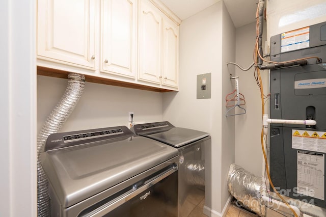 clothes washing area featuring cabinets, tile patterned floors, heating unit, and washing machine and clothes dryer