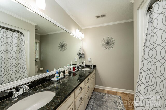 bathroom featuring vanity, crown molding, tile patterned floors, and toilet