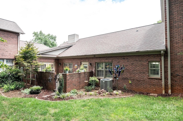 rear view of house with a yard and central AC unit