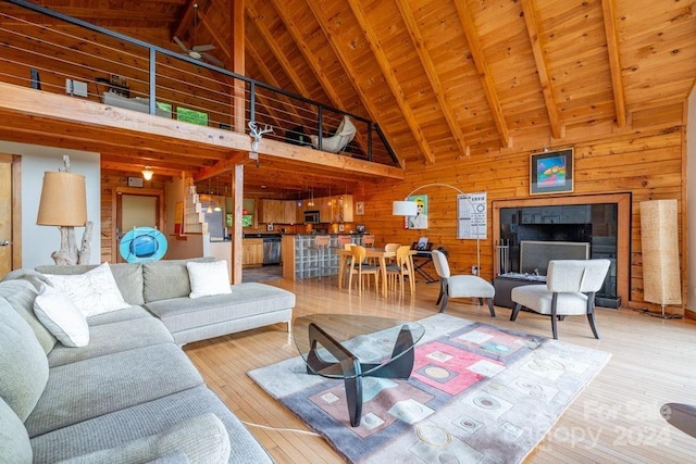 living room featuring wood ceiling, hardwood / wood-style flooring, beam ceiling, wooden walls, and high vaulted ceiling