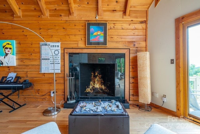 room details featuring a tile fireplace, wood-type flooring, and wooden walls