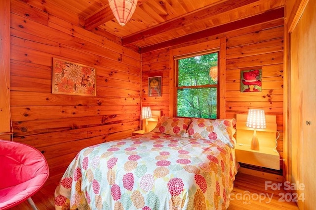 bedroom featuring beamed ceiling, wood ceiling, and wood walls