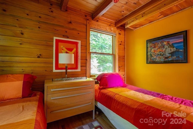 bedroom featuring beam ceiling, wooden walls, wooden ceiling, and hardwood / wood-style flooring