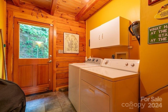 laundry room featuring cabinets, wood ceiling, washer and clothes dryer, and wood walls