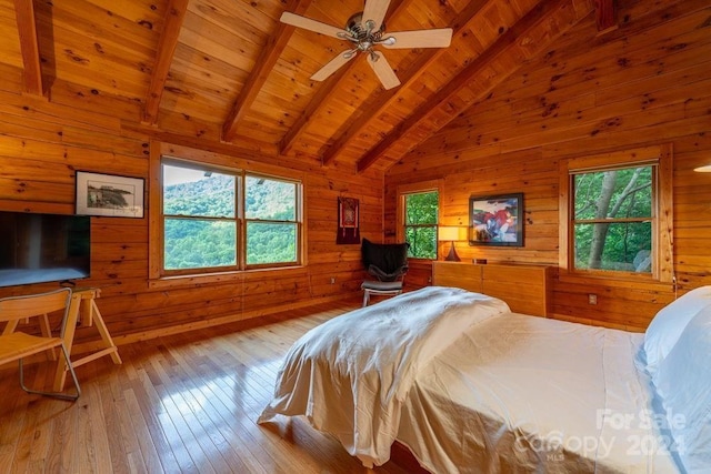 bedroom featuring wood ceiling, wooden walls, light hardwood / wood-style flooring, and vaulted ceiling with beams