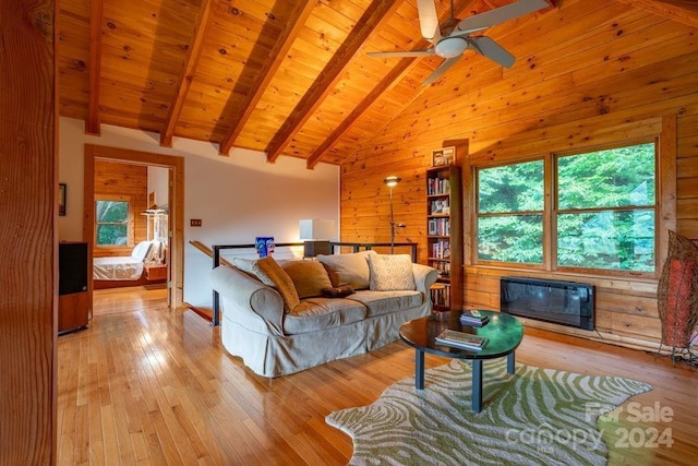 living room with light hardwood / wood-style flooring, wooden walls, high vaulted ceiling, wooden ceiling, and beamed ceiling