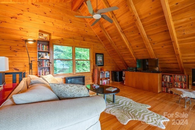 living room featuring lofted ceiling with beams, wooden walls, wood ceiling, and light wood-type flooring