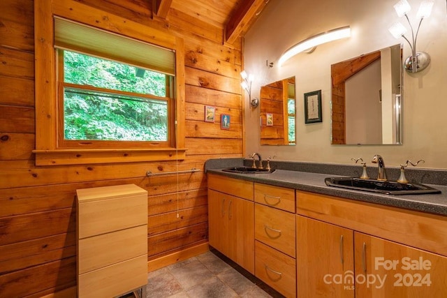 bathroom featuring vanity, beam ceiling, and wood walls