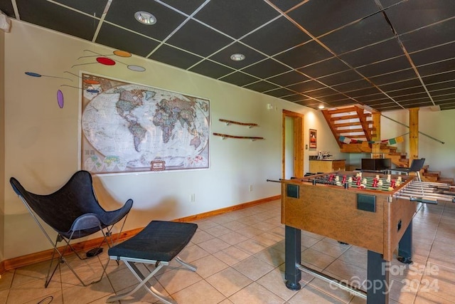 rec room with tile patterned flooring and a paneled ceiling