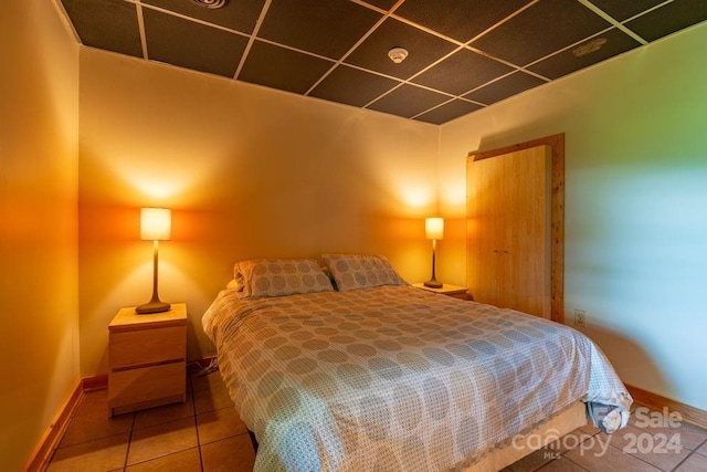 tiled bedroom featuring a drop ceiling