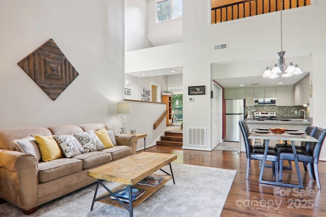 living room with an inviting chandelier and hardwood / wood-style flooring