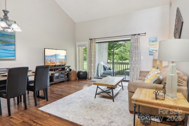 living room featuring high vaulted ceiling, dark wood-type flooring, and a chandelier