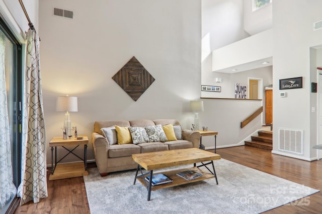 living room with dark hardwood / wood-style floors and a high ceiling