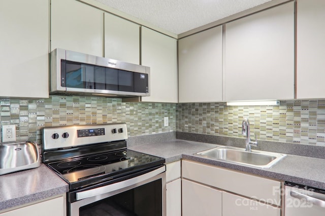 kitchen featuring sink, appliances with stainless steel finishes, tasteful backsplash, a textured ceiling, and white cabinets