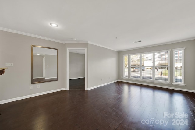 empty room featuring dark hardwood / wood-style flooring and ornamental molding