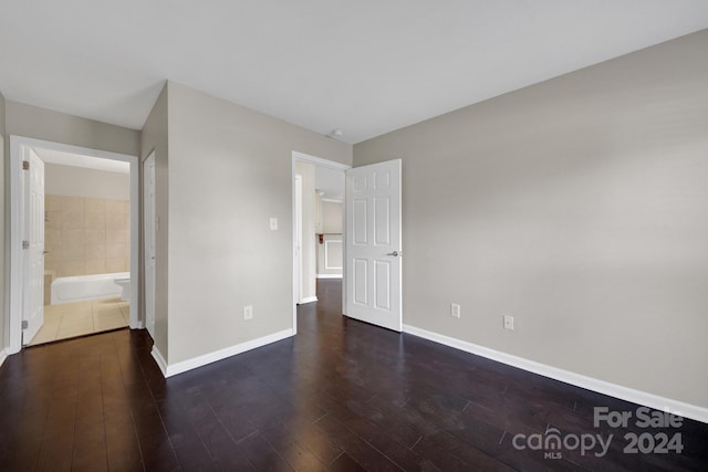 unfurnished bedroom featuring dark hardwood / wood-style flooring and ensuite bathroom