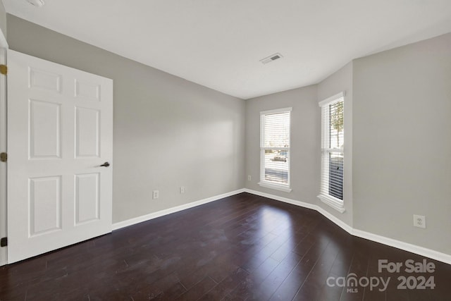 empty room with dark hardwood / wood-style flooring