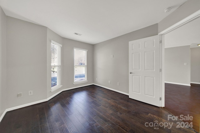 unfurnished room with dark hardwood / wood-style flooring